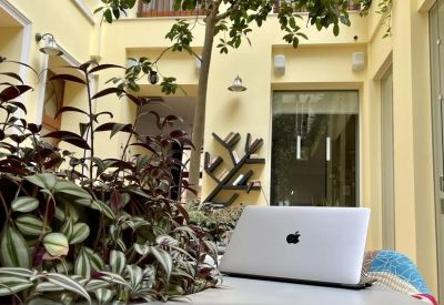 Cozy workspace nook with wooden accents and a laptop on a white table.