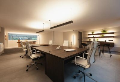 Private meeting room with a large wooden table and floor-to-ceiling glass windows.