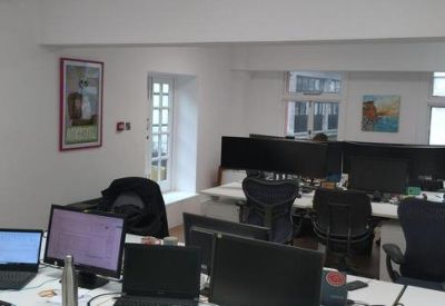 Open-plan workspace with multiple desks and monitors.