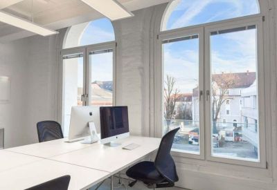 Office with arched windows and computer on the desk.