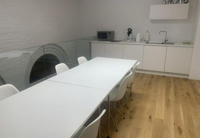 Meeting room with kitchenette and modern appliances.