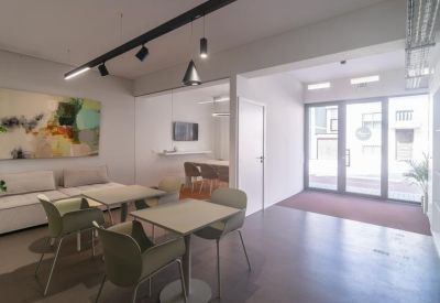 Modern dining area with square tables and green chairs.