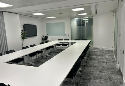 Spacious conference room with a modular table setup and bright LED panel lighting.