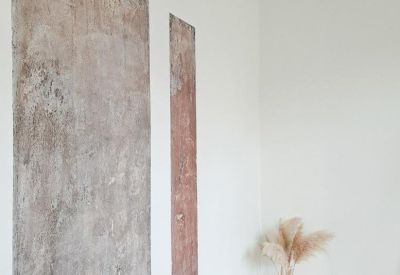 White hallway area featuring large abstract wall art and light wood floors.