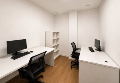 Private two-person office suite featuring white desks and a shelving unit.