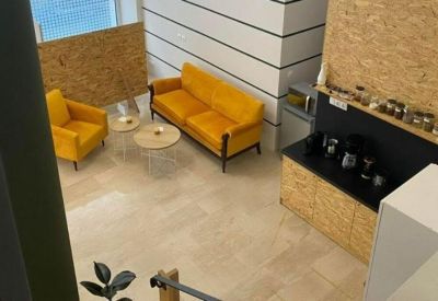 Aerial view of a bright lounge area with yellow sofas and a coffee station.