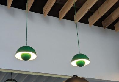Close-up of stylish green and white dome pendant lights hanging from a timber slatted ceiling.