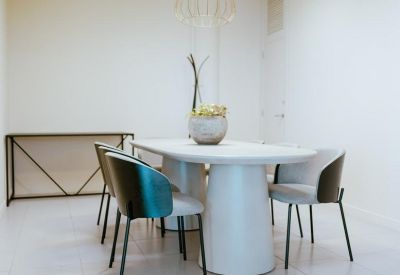 Sleek white oval meeting table surrounded by modern grey and black bucket chairs.