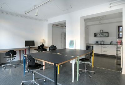 Clean office kitchen area with white cabinets and integrated appliances.