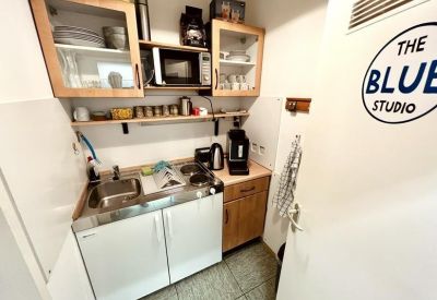 Compact kitchenette area with wooden cabinetry, a microwave, and a sink.