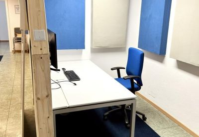 Private office at 7, Kemptener Straße with blue acoustic panels and a white desk.