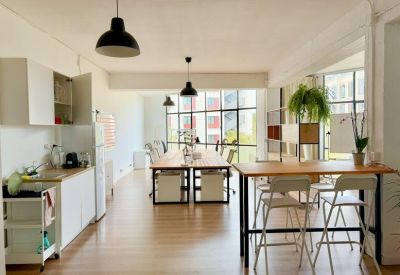 Office interior view from the kitchenette towards the open-plan workspace.