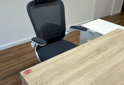 Close-up of a modern black mesh ergonomic office chair with a headrest.