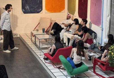 Casual meeting area with people sitting on colorful mid-century modern chairs.