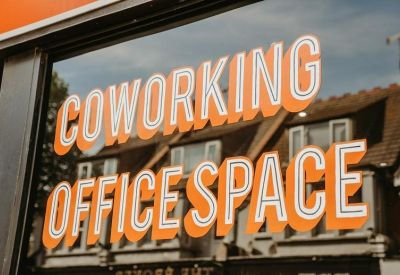 Exterior signage for Office Central, 9a Fairfax Drive, featuring orange typography on a glass window.