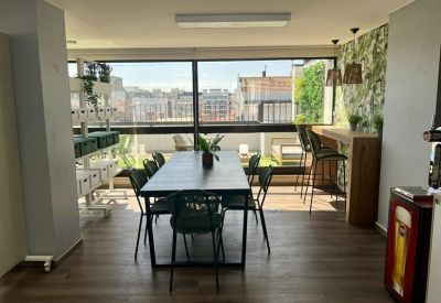 Communal dining area with a long black table and high-top seating overlooking the city.