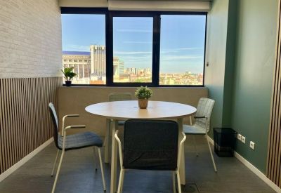 Small meeting room with a round wooden table and views of the city skyline.