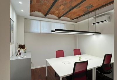 Internal four-person meeting room with a white table and vaulted brick ceiling.