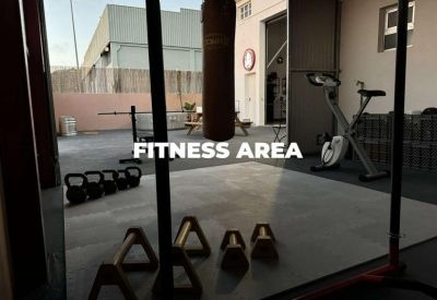 Fitness area with a punching bag, stationary bike, and kettlebells.