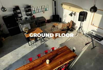 Spacious communal ground floor area with long wooden tables and various seating options.