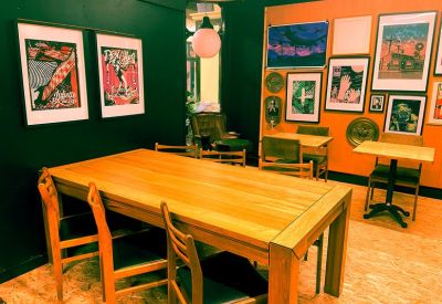 Large wooden meeting table surrounded by chairs and framed artwork.