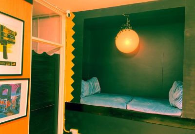 A cozy built-in reading nook with blue cushions and a spherical pendant light.