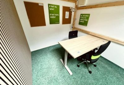 Modern meeting or focus room with a standing desk and cork bulletin boards.