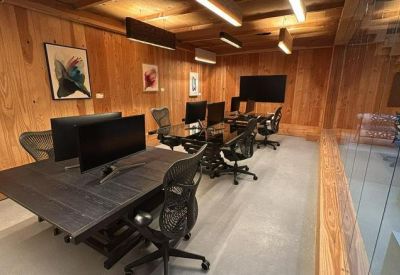 Collaborative office area with multiple monitors and timber walls.