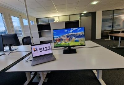 Office desk setup with laptop and large monitor.