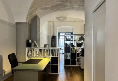 Spacious workspace with vaulted ceilings and wooden floors at Piazza Maravigna.
