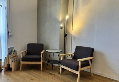 Cozy lounge area featuring two dark armchairs and a small side table.