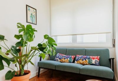 Cozy break area with a green sofa, colorful pillows, and parquet floors.