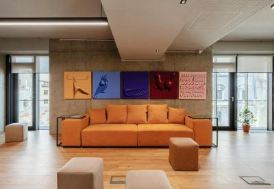 Lounge area with an orange couch and colorful art on the wall.