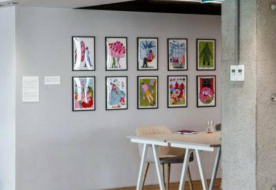 Small meeting area with artistic wall decor and simple furniture.