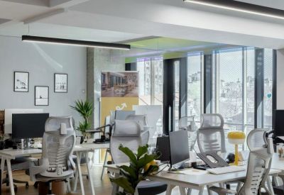 Bright workspace with multiple ergonomic chairs and large windows.