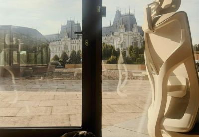 Office with ergonomic chair and large window view of historical building.