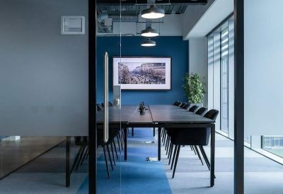 Professional boardroom with a long dark table and blue feature wall.