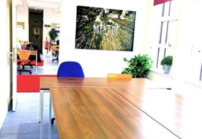 Large wooden meeting table with blue and orange chairs.