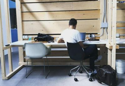 Wooden workstation nook featuring a desk, chair, and a dog resting on the floor.