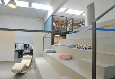 Modern breakout area with tiered stadium-style seating and colorful cushions.