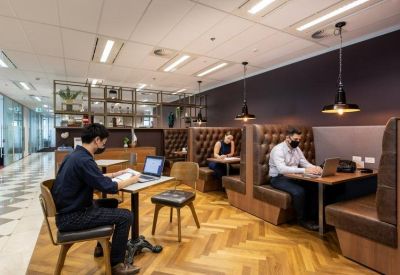 Bright open-plan office space with herringbone floors and booth seating.