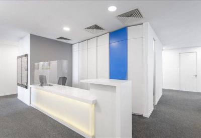 Bright reception desk with warm under-lighting and blue vertical wall panels.