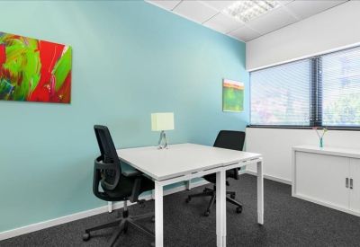 Private office featuring a light blue accent wall and two workstations with black mesh chairs.