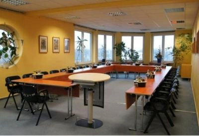 Large boardroom with U-shaped table arrangement and bright yellow feature walls.