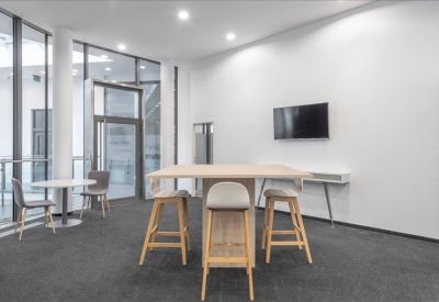 Communal breakout area with a high table and stools.
