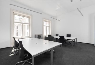 Open office space with multiple desks and large windows.