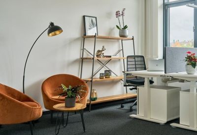 Cozy lounge area featuring orange velvet armchairs and a modern bookshelf.
