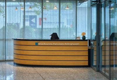 Modern reception desk with wood paneling and elegant hanging pendant lights.