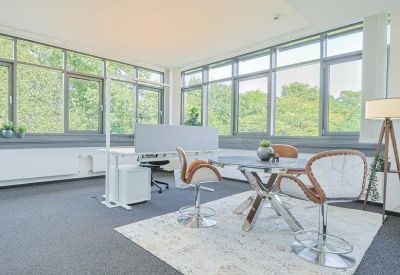 Modern meeting room with a round glass table and contemporary brown chairs.