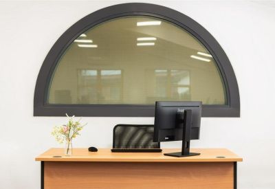 Reception desk featuring a large arched window overlooking an internal office.